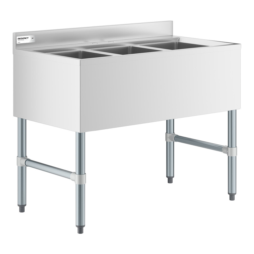 A stainless steel three-compartment sink with a backsplash and four metal legs.
