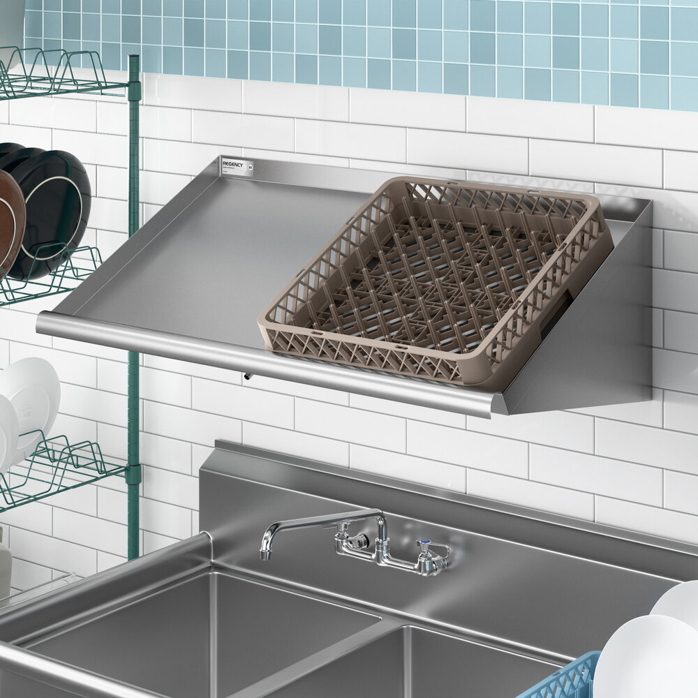 A stainless steel 42-inch wall-mounted slanted rack shelf with a dish rack placed on top, installed above a commercial sink.