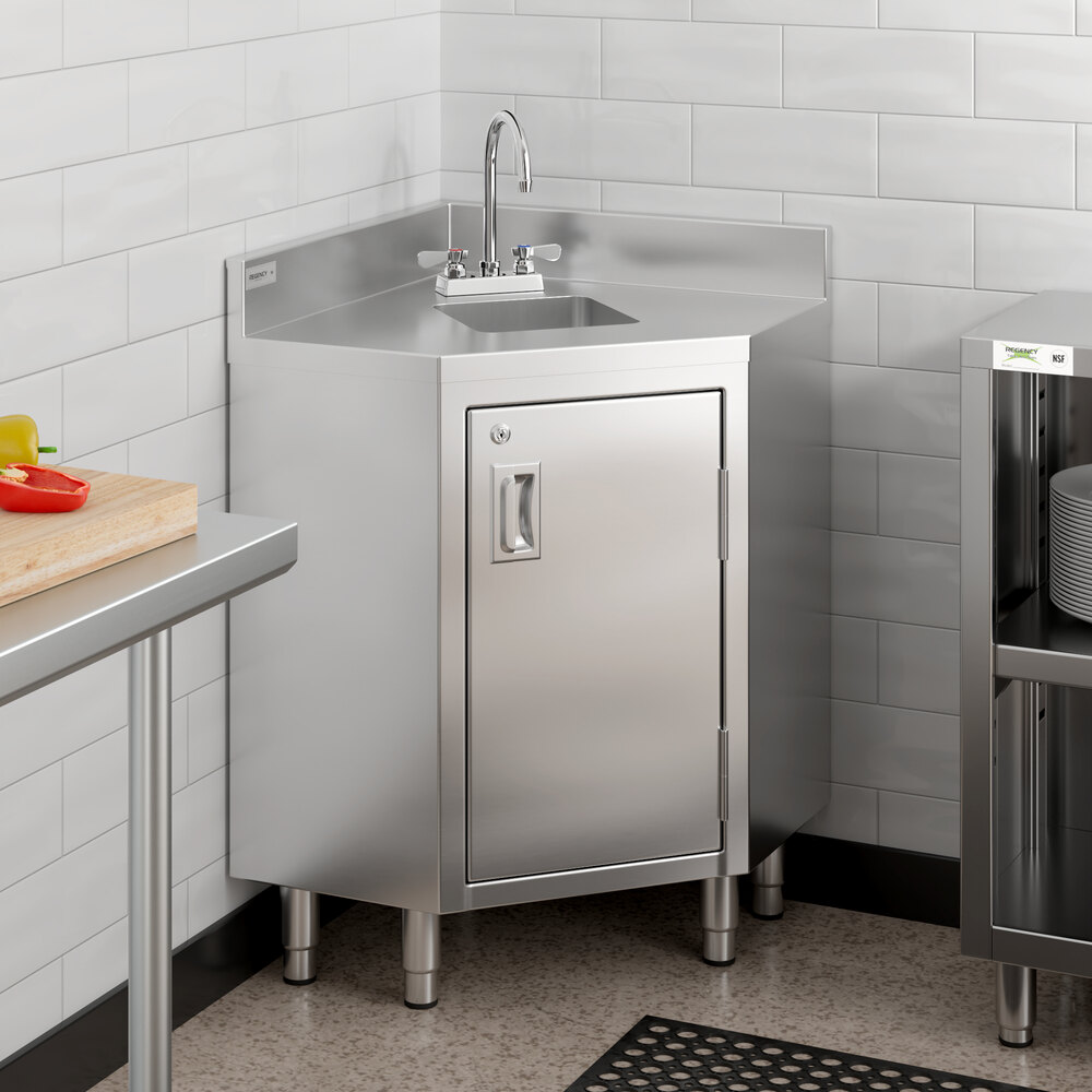 A Regency stainless steel corner work table with sink, hinged door, and lock.