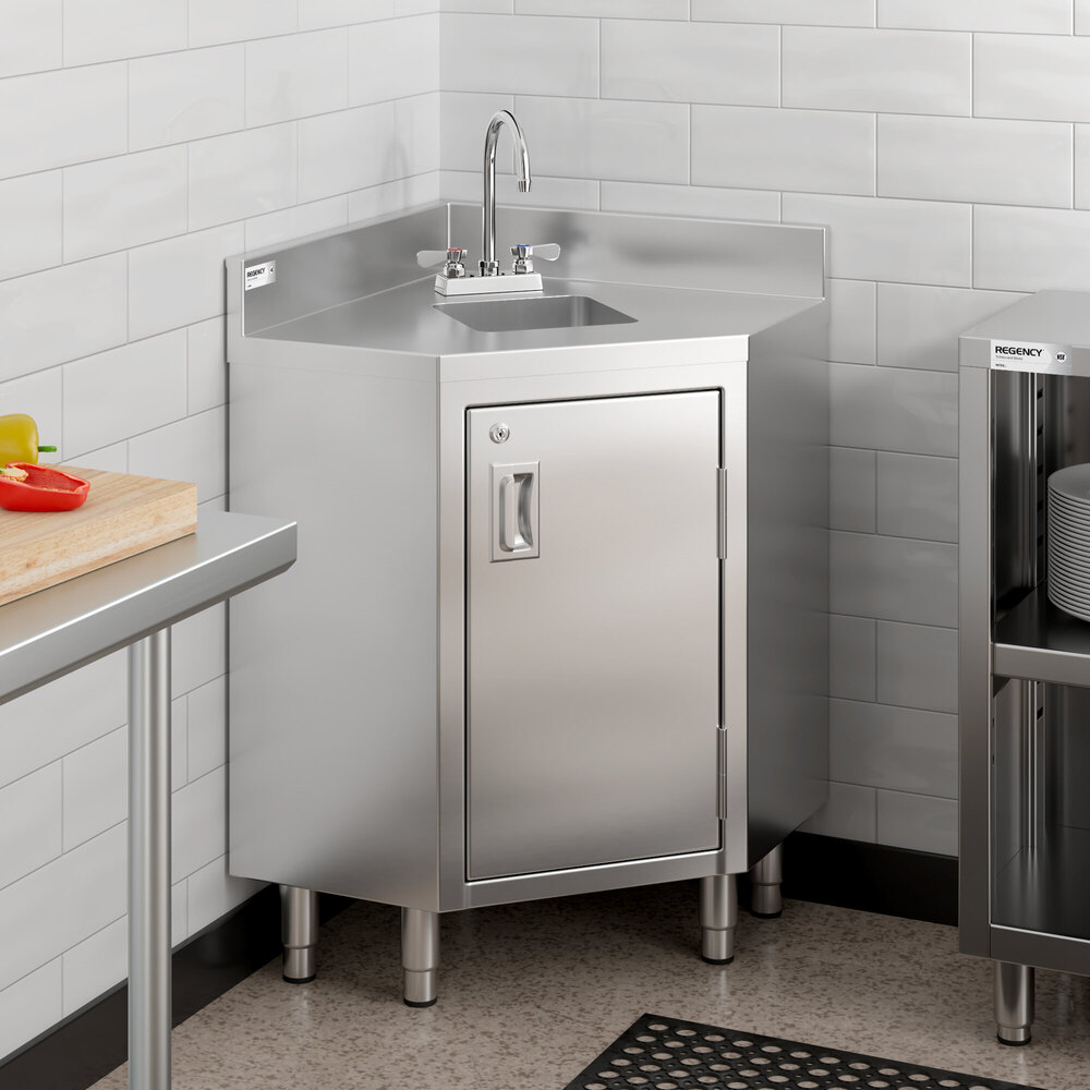 A stainless steel corner work table with an integrated sink, faucet, and a lockable hinged door, positioned in a tiled kitchen corner.