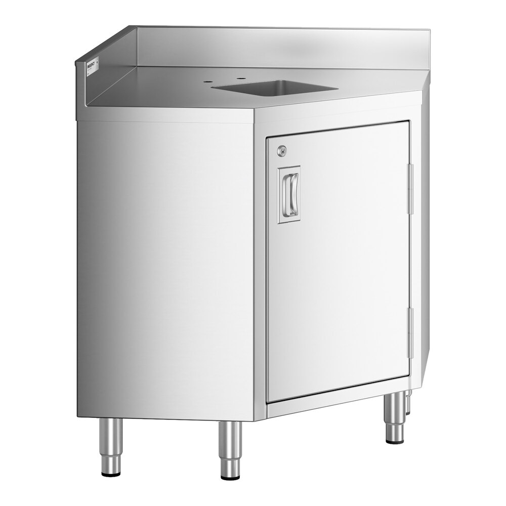 A stainless steel corner work table with a small integrated sink, a hinged door with a handle, and four sturdy legs.