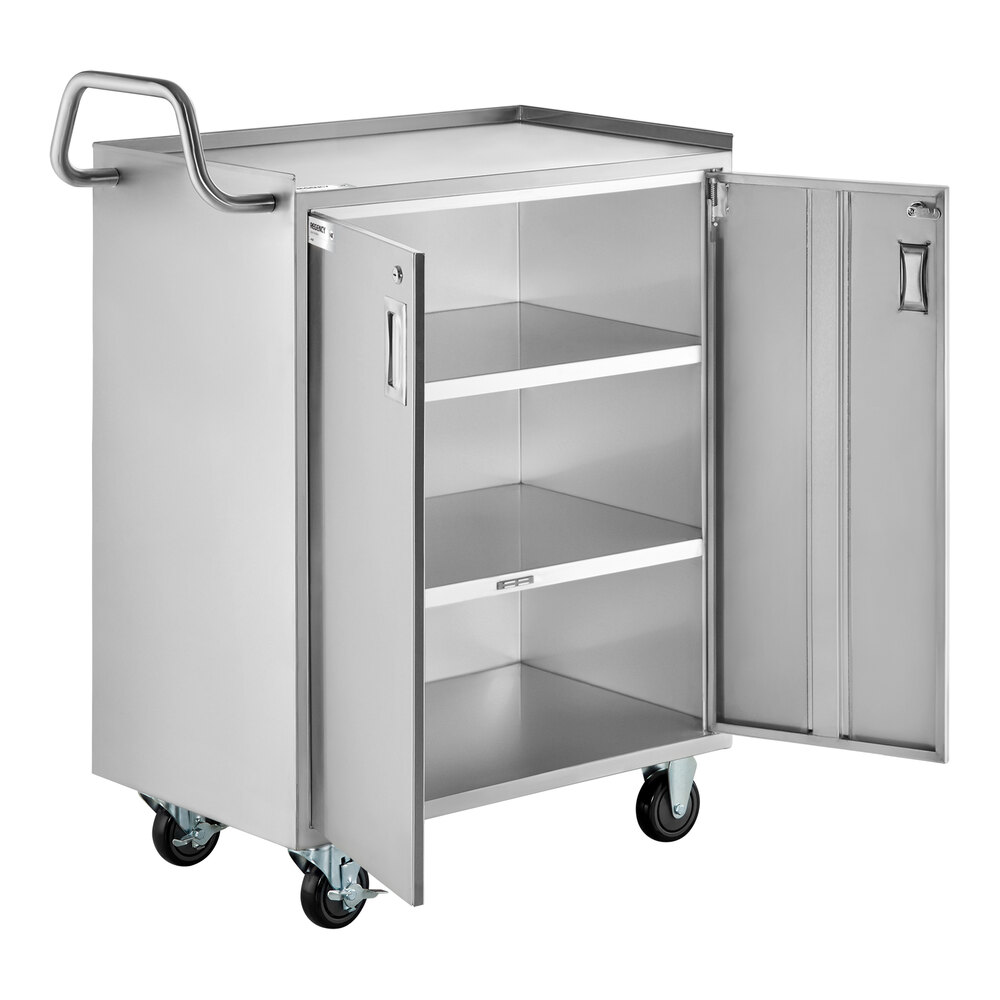 A stainless steel utility cart with four wheels, a handle, and an enclosed base featuring two open doors revealing three interior shelves.