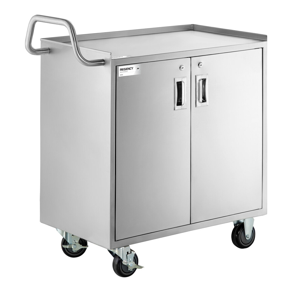 A stainless steel utility cart with an enclosed base, two locking doors, a handle, and four caster wheels.