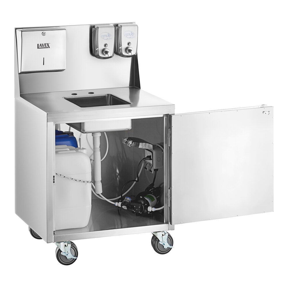 A stainless steel portable hand sink cart with a single bowl, paper towel dispenser, two soap dispensers, and an open cabinet showing water containers and plumbing components, all mounted on wheels.