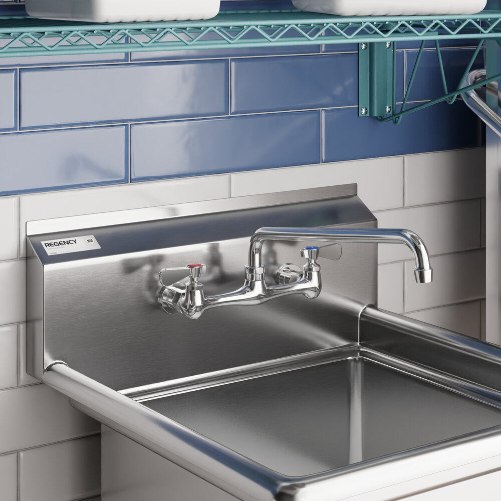 A stainless steel wall mount faucet with a 14-inch swing spout and 8-inch centers installed above a commercial sink.