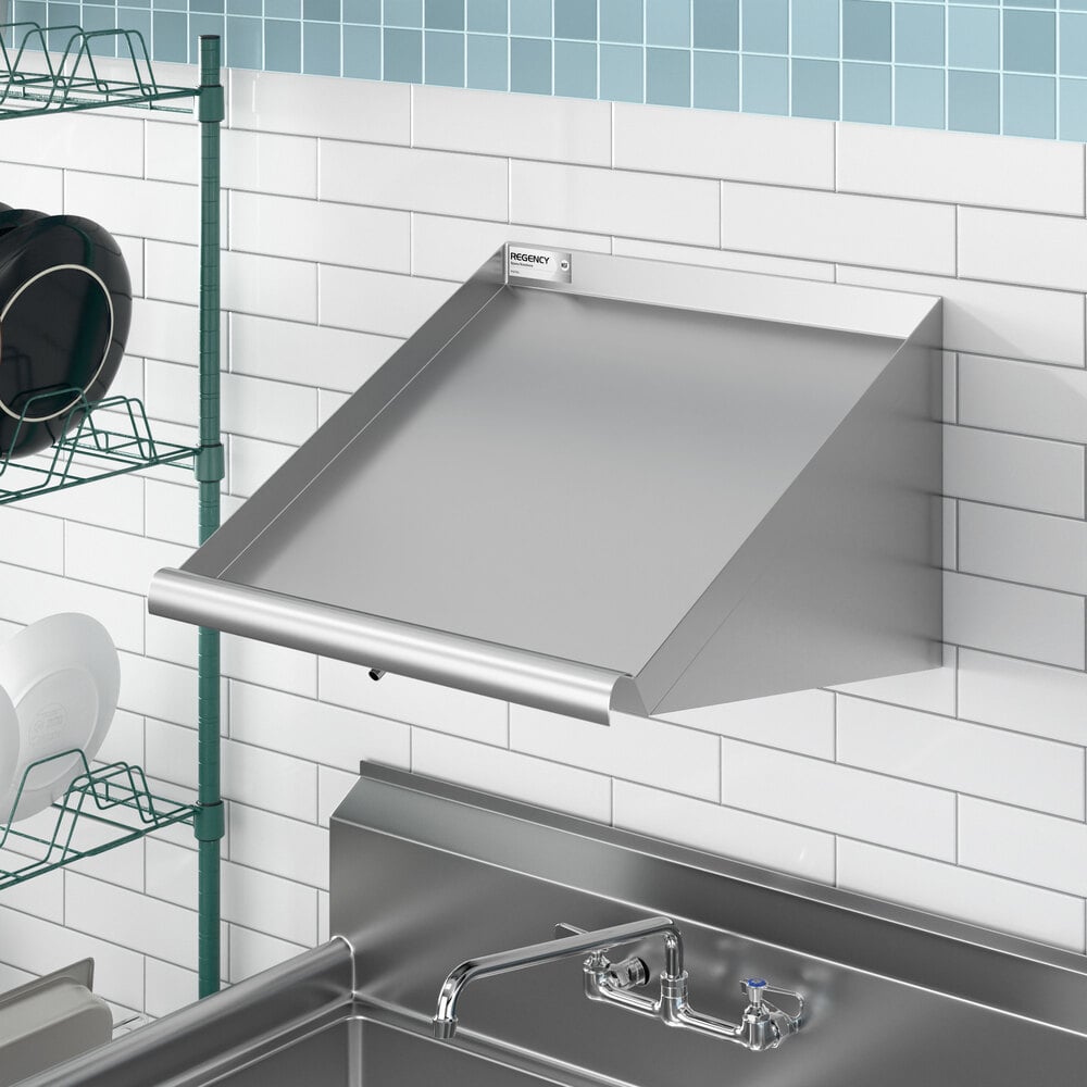 A stainless steel 21-inch wall mounted slanted rack shelf installed above a sink in a kitchen setting.