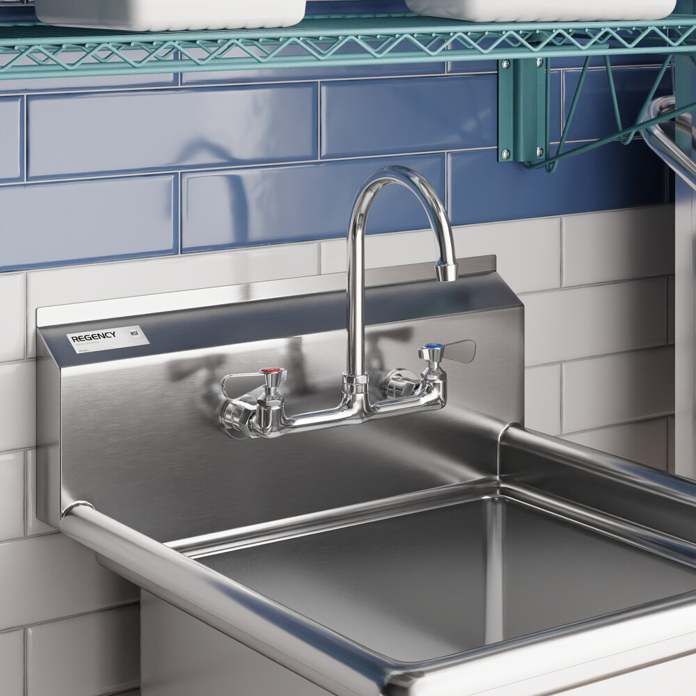 A stainless steel wall mount faucet with 8-inch centers and a 6-inch swivel gooseneck spout installed above a utility sink.