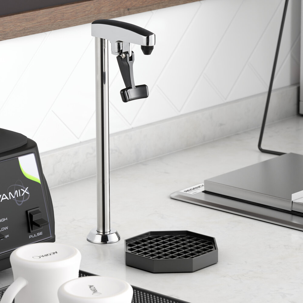 A tall, chrome-finished countertop glass filler with a lever spout, positioned next to a black drip tray on a kitchen counter.