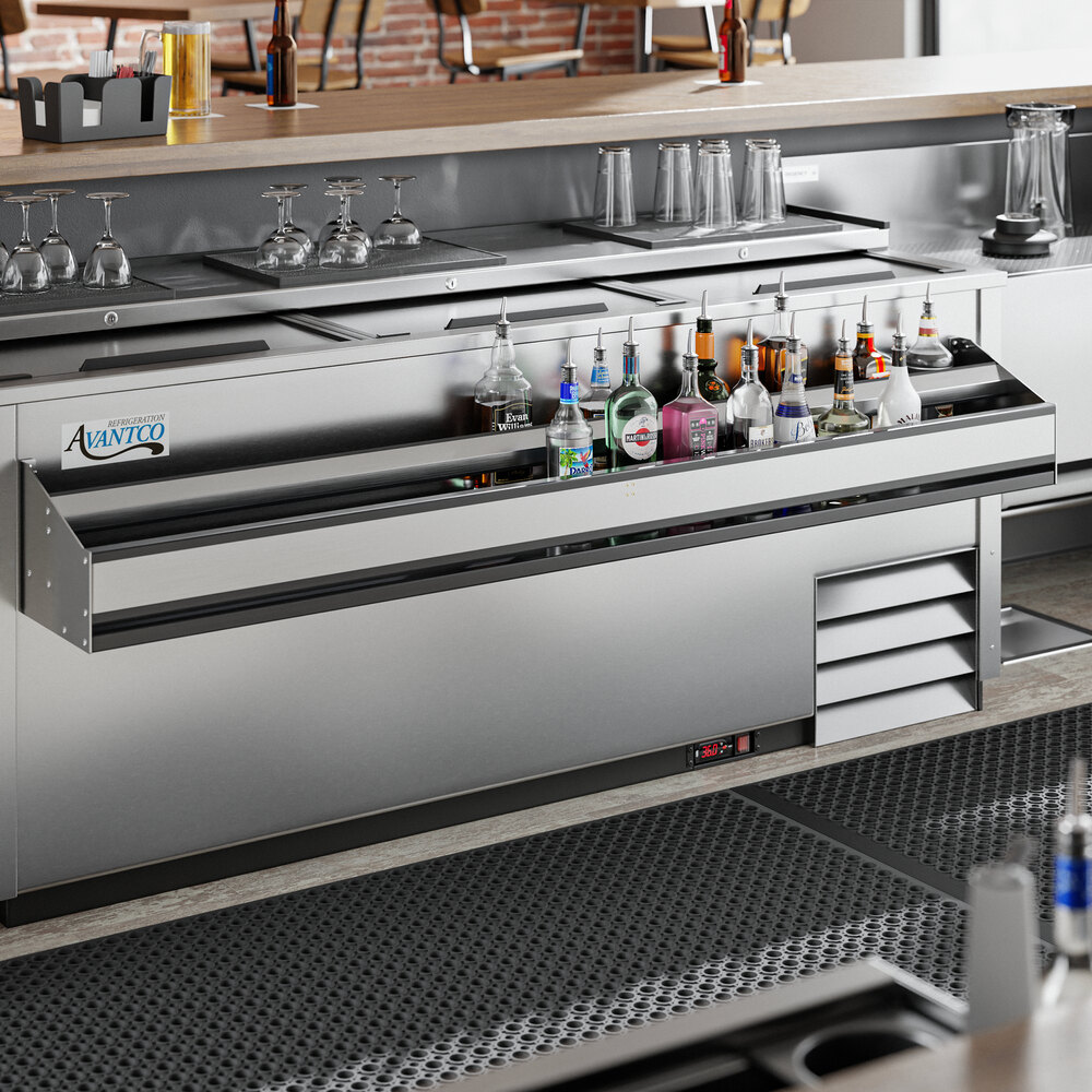 A Regency stainless steel double tier speed rail holding bottles and glasses on a bar counter.