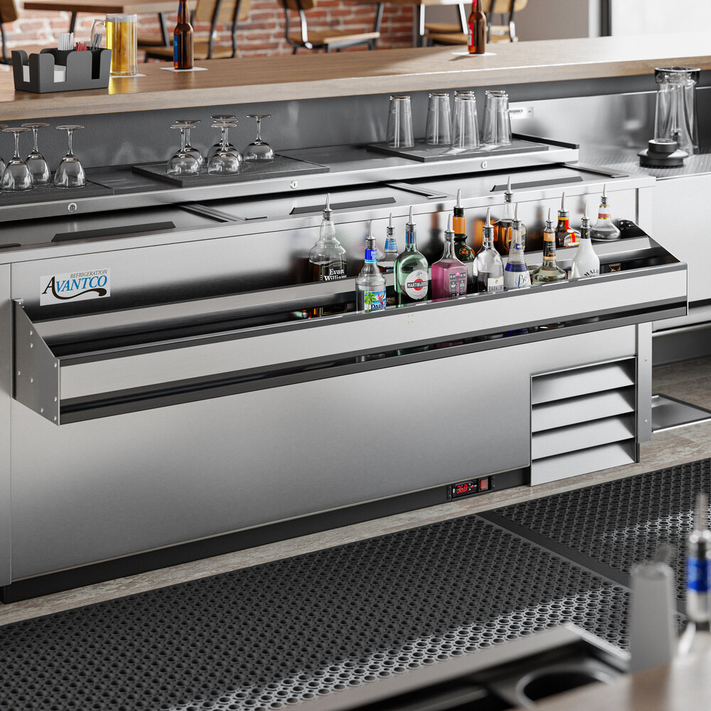 A stainless steel double-tier speed rail attached to a bar counter, holding various bottles of liquor.