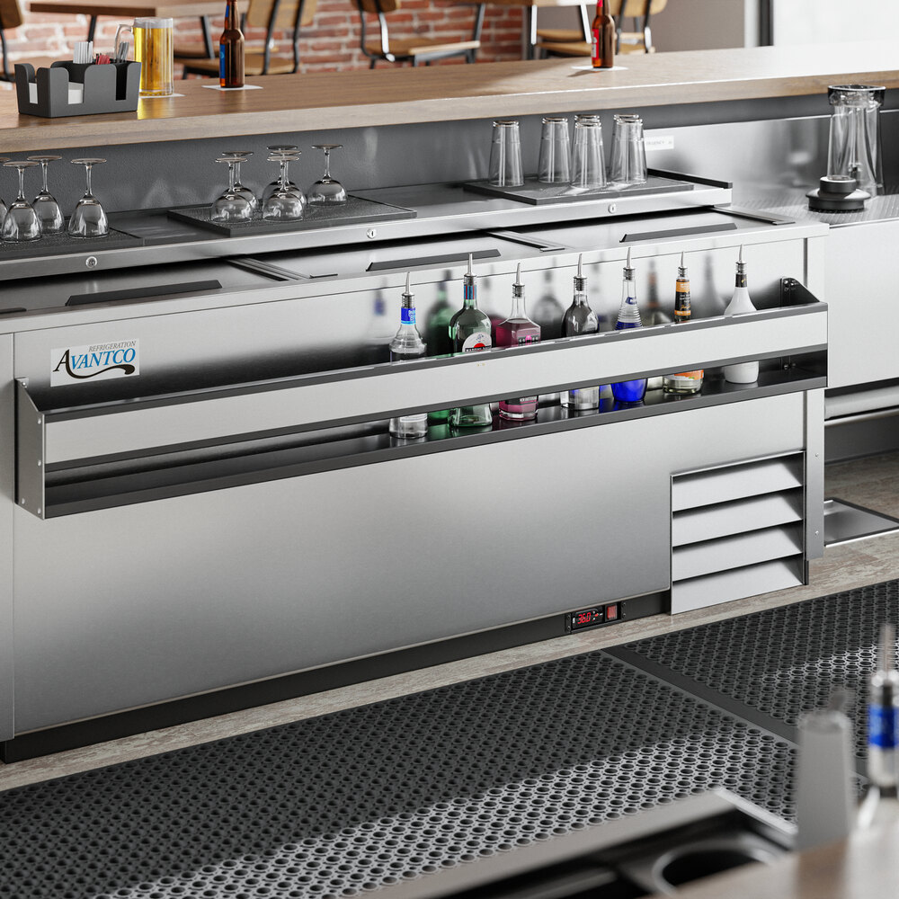 A Regency stainless steel speed rail on a bar counter with bottles and glasses.
