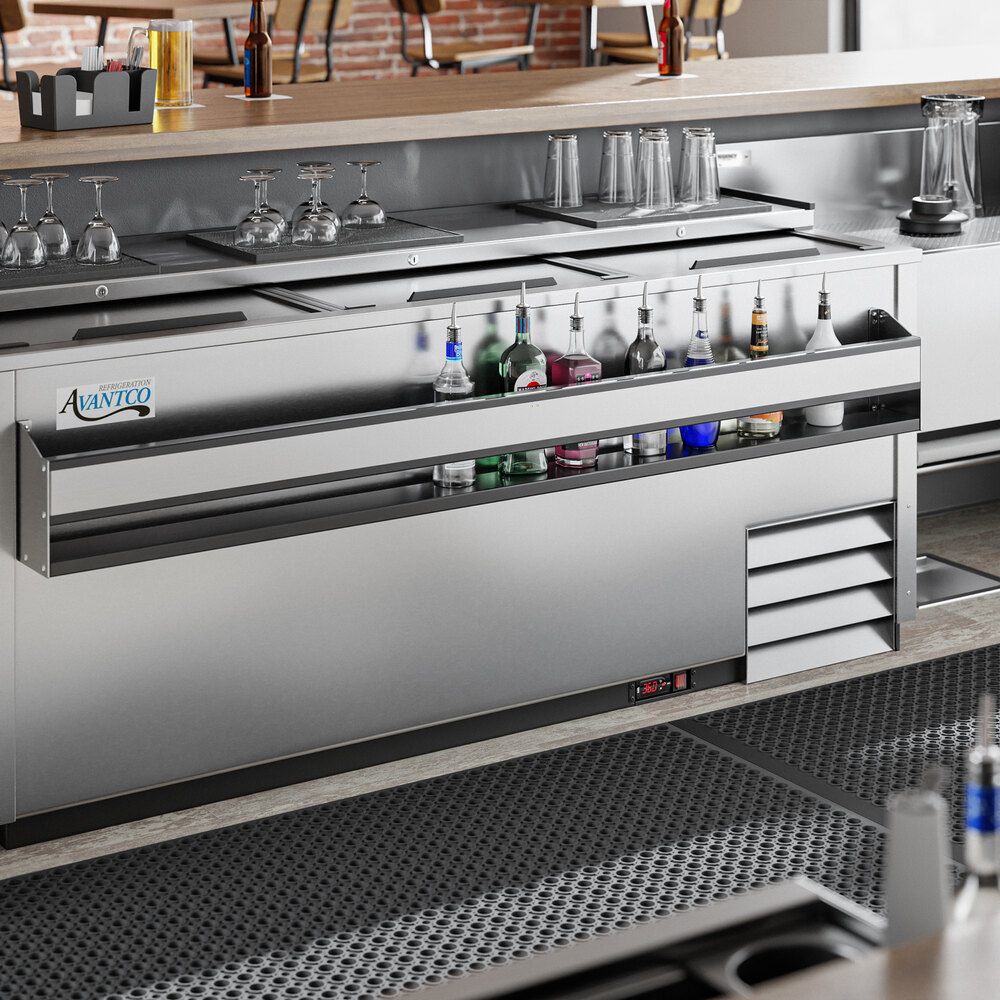 A stainless steel single-tier speed rail attached to a bar counter, holding various bottles of liquor.