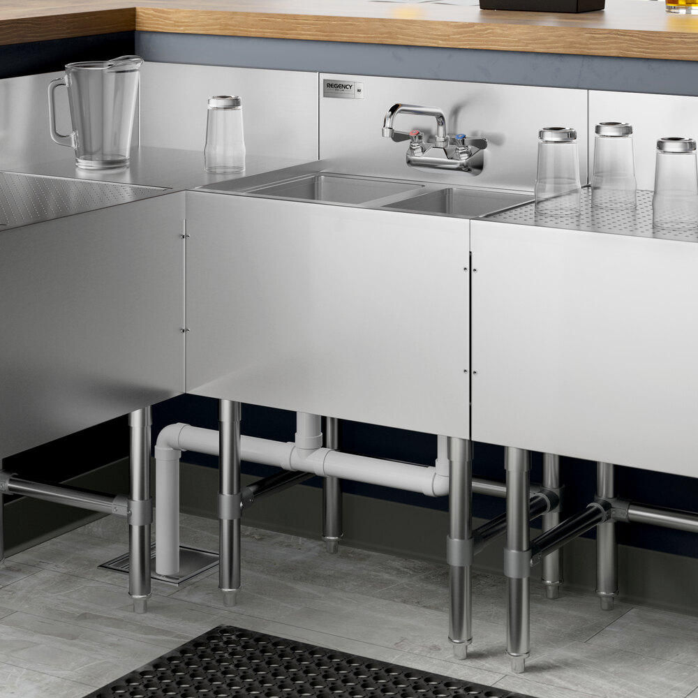 A Regency stainless steel underbar sink with two bowls on a counter.