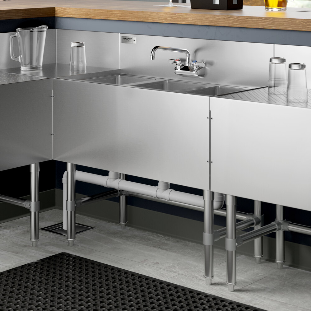 A Regency stainless steel underbar sink with three bowls and a faucet on a counter.