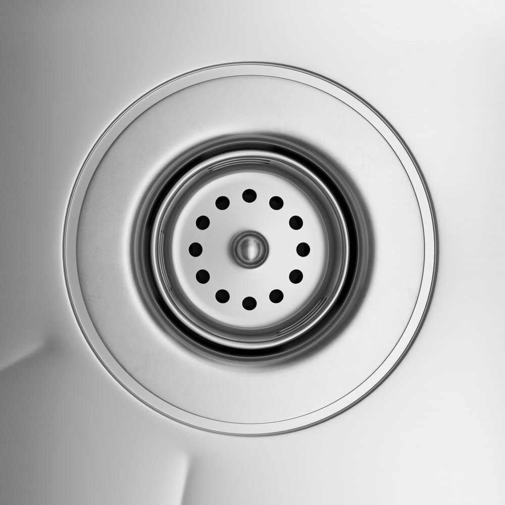 A close up of the drain on a Regency stainless steel underbar sink.