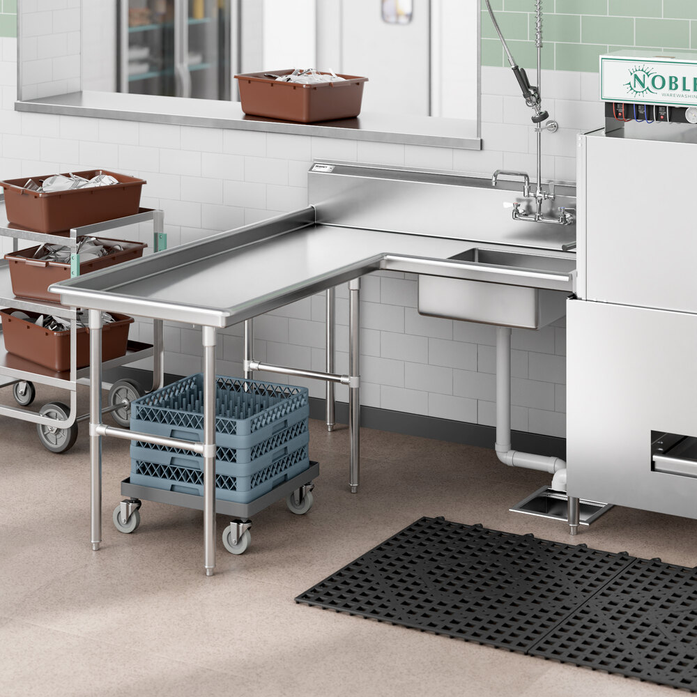 A stainless steel L-shaped dishtable with an integrated sink, positioned next to a commercial dishwasher in a kitchen setting.