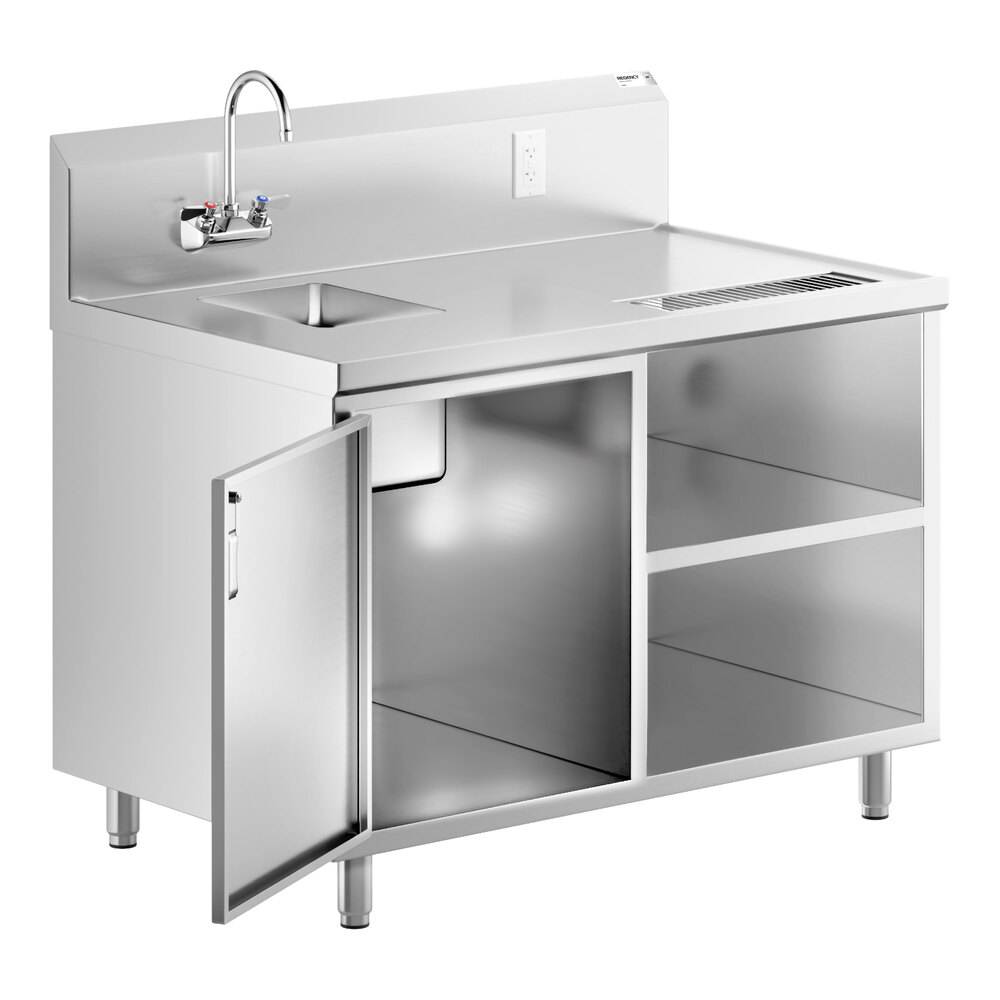 A stainless steel beverage table with a left-side sink, gooseneck faucet, backsplash, open shelving, and one cabinet door open to reveal storage space underneath.