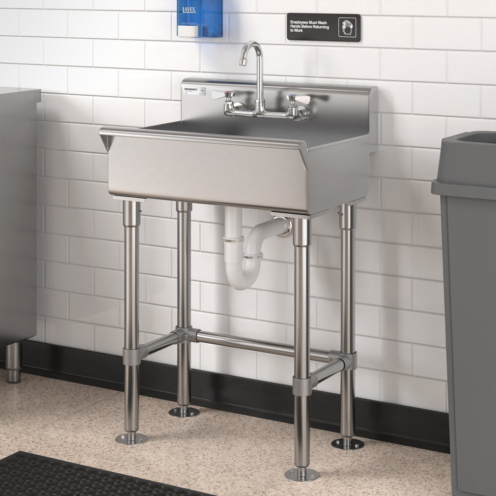 A stainless steel hand sink with four legs, a backsplash, and an 8-inch center faucet, installed against a tiled wall.