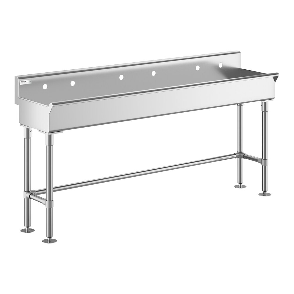 A large, rectangular stainless steel sink with four legs and a high backsplash featuring three faucet holes.