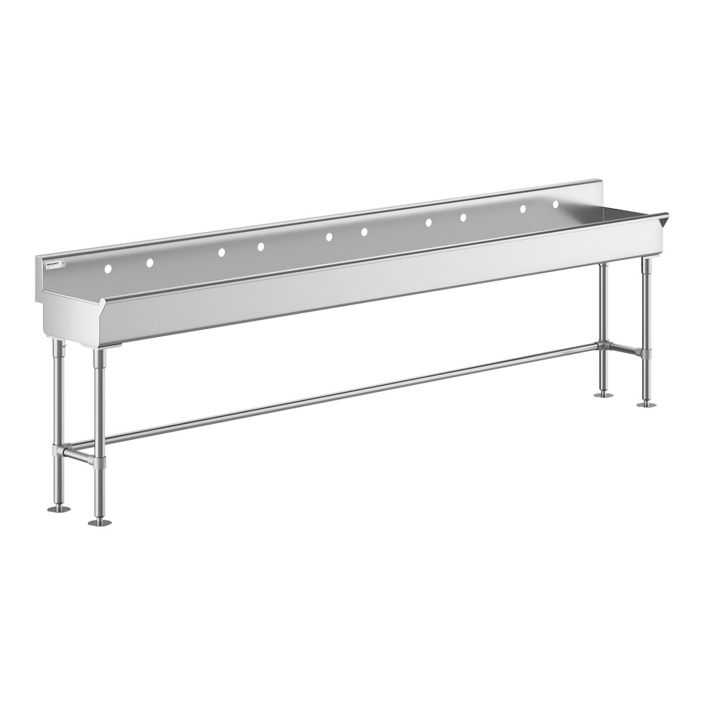 A long, stainless steel hand sink with five faucet mounting holes and four supporting legs.