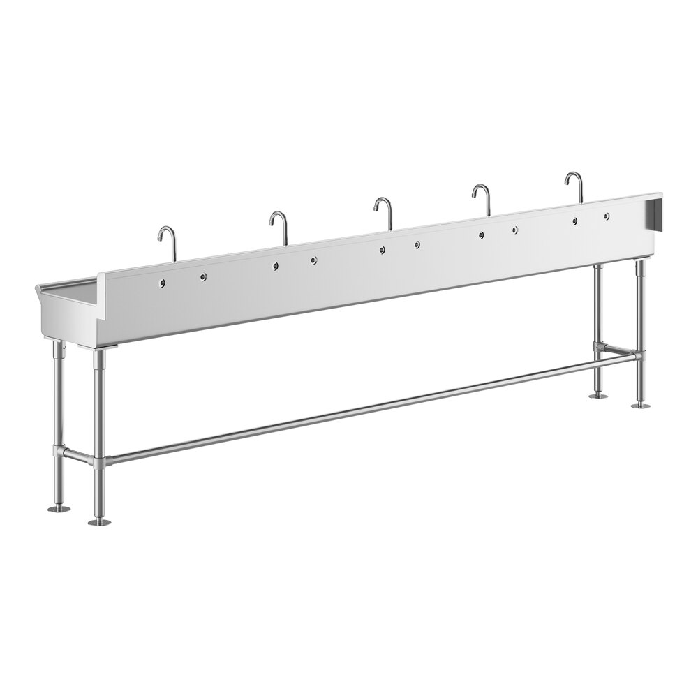 A long, stainless steel hand sink with five evenly spaced faucets and sturdy metal legs.