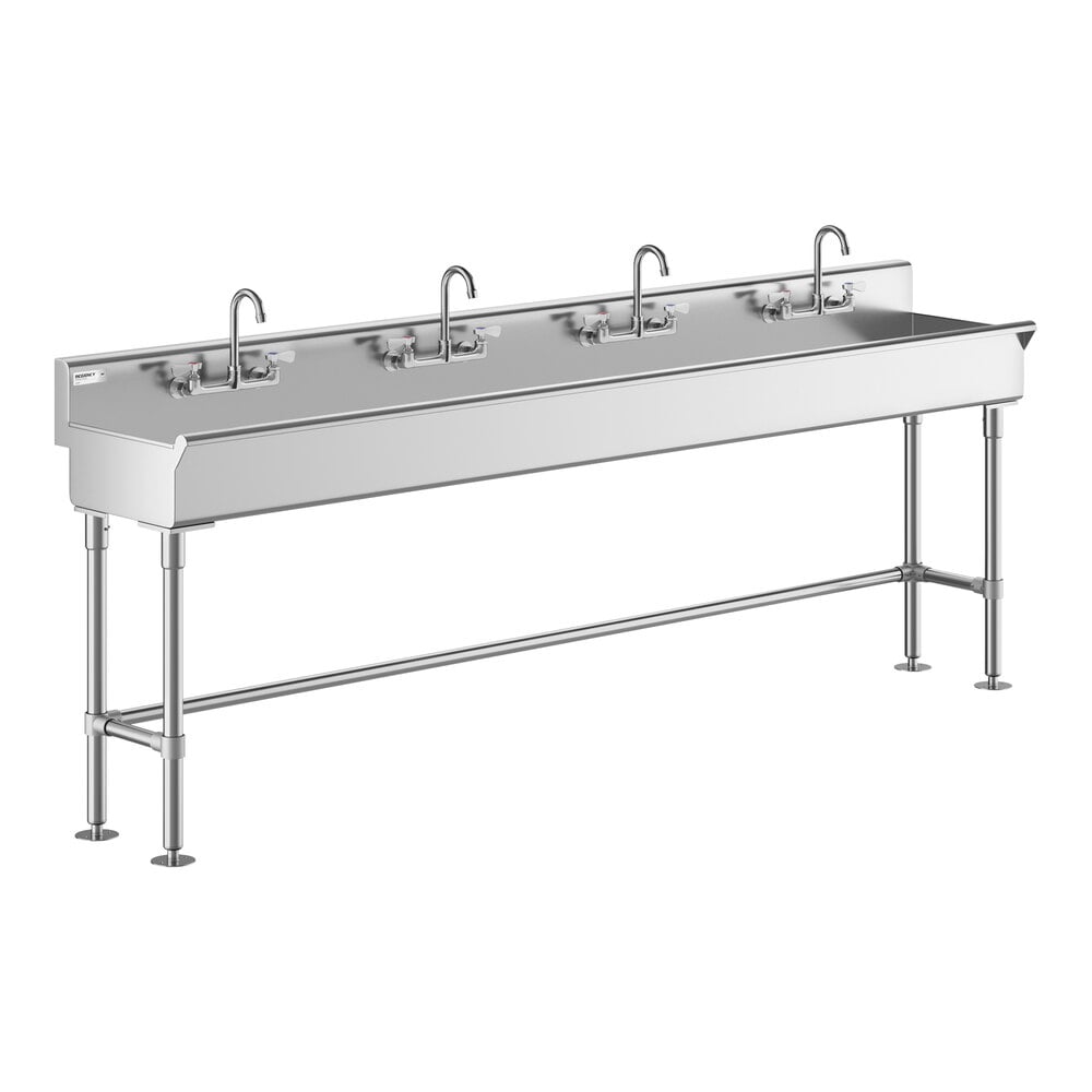 A long stainless steel sink with four faucets and sturdy metal legs.