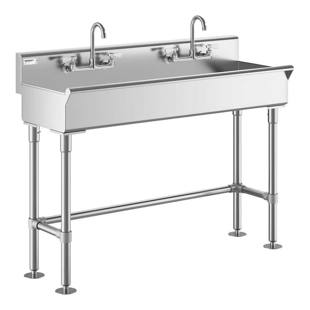 A stainless steel double hand sink with two faucets and four sturdy legs.