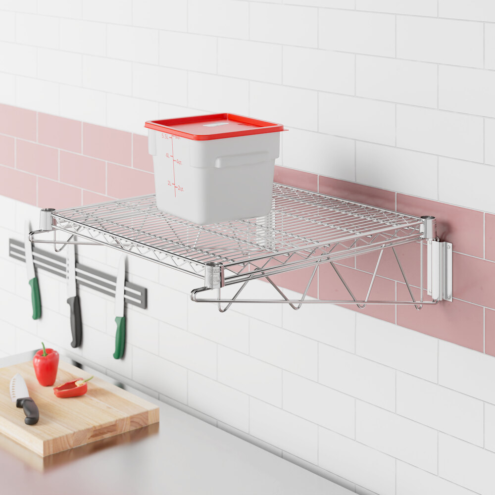 A Regency stainless steel wall-mount wire shelf holding a container.