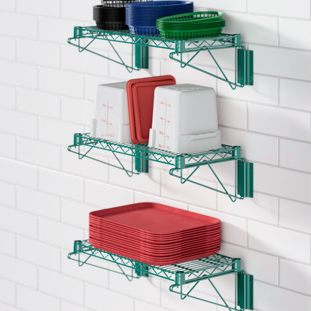 A Regency green epoxy wire shelf with dishes and pots on it.