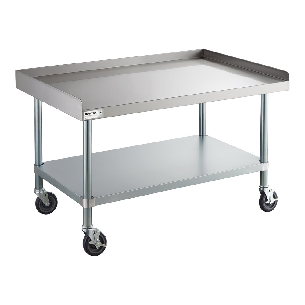 A stainless steel equipment stand with a raised edge, an undershelf, and four caster wheels.