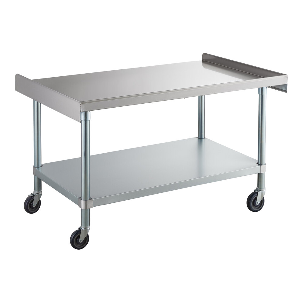 A stainless steel table with a lower shelf and four caster wheels, featuring a raised edge on three sides of the top surface.