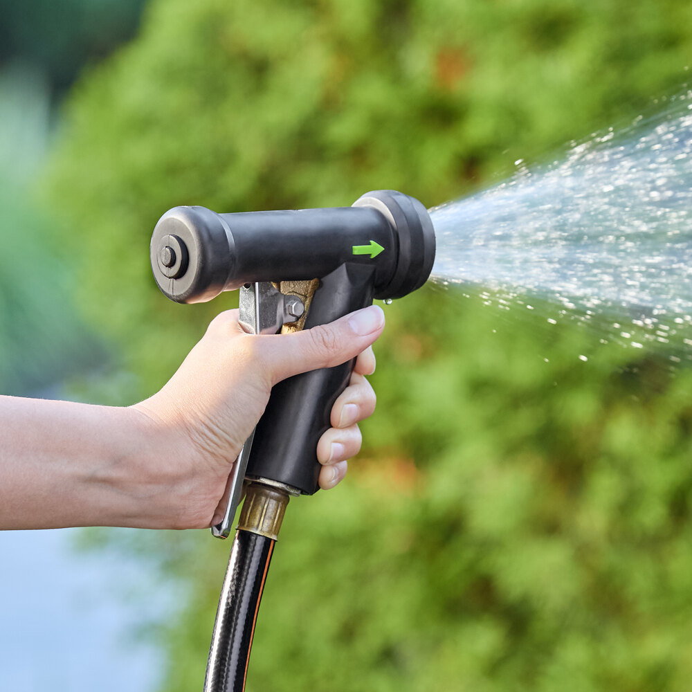 A black aluminum spray nozzle with a metal handle attached to a hose, spraying water.