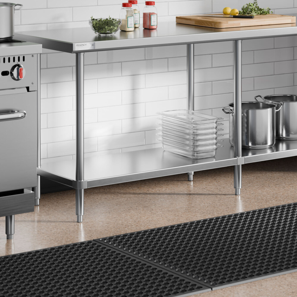 An 18-gauge stainless steel adjustable undershelf designed for 30-inch by 108-inch work tables, shown installed beneath a kitchen work table.