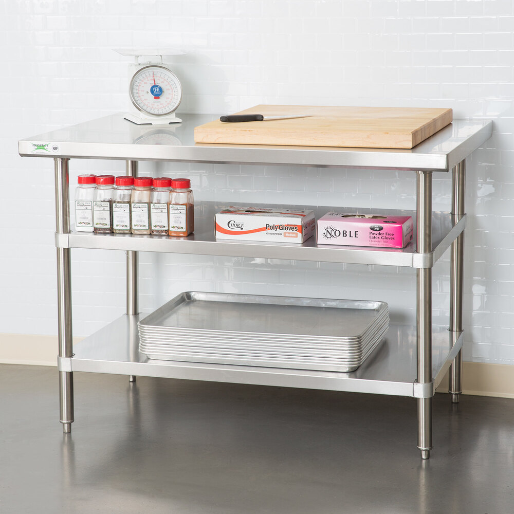 A stainless steel adjustable undershelf designed for 18-inch by 48-inch work tables, shown installed with kitchen supplies and equipment.