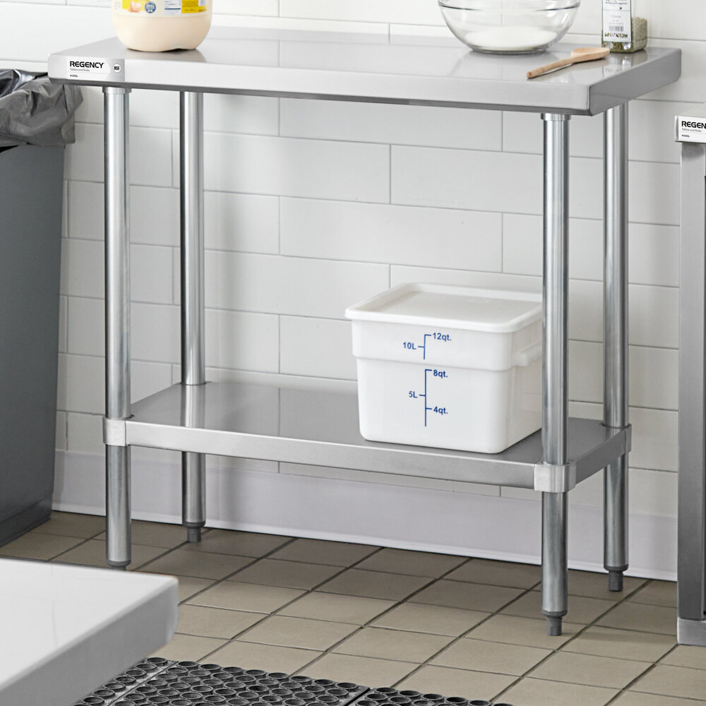 A stainless steel work table with an adjustable undershelf, holding a white storage container with measurement markings.
