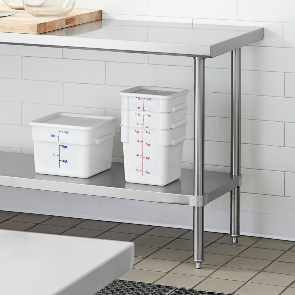 A stainless steel adjustable undershelf installed on a work table, holding several white food storage containers.