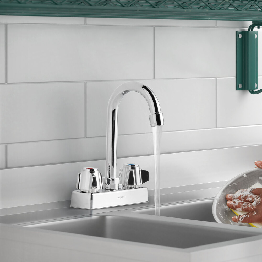 A chrome deck-mount kitchen faucet with a 3 1/2 inch swivel gooseneck spout and dual handles, installed on a sink.