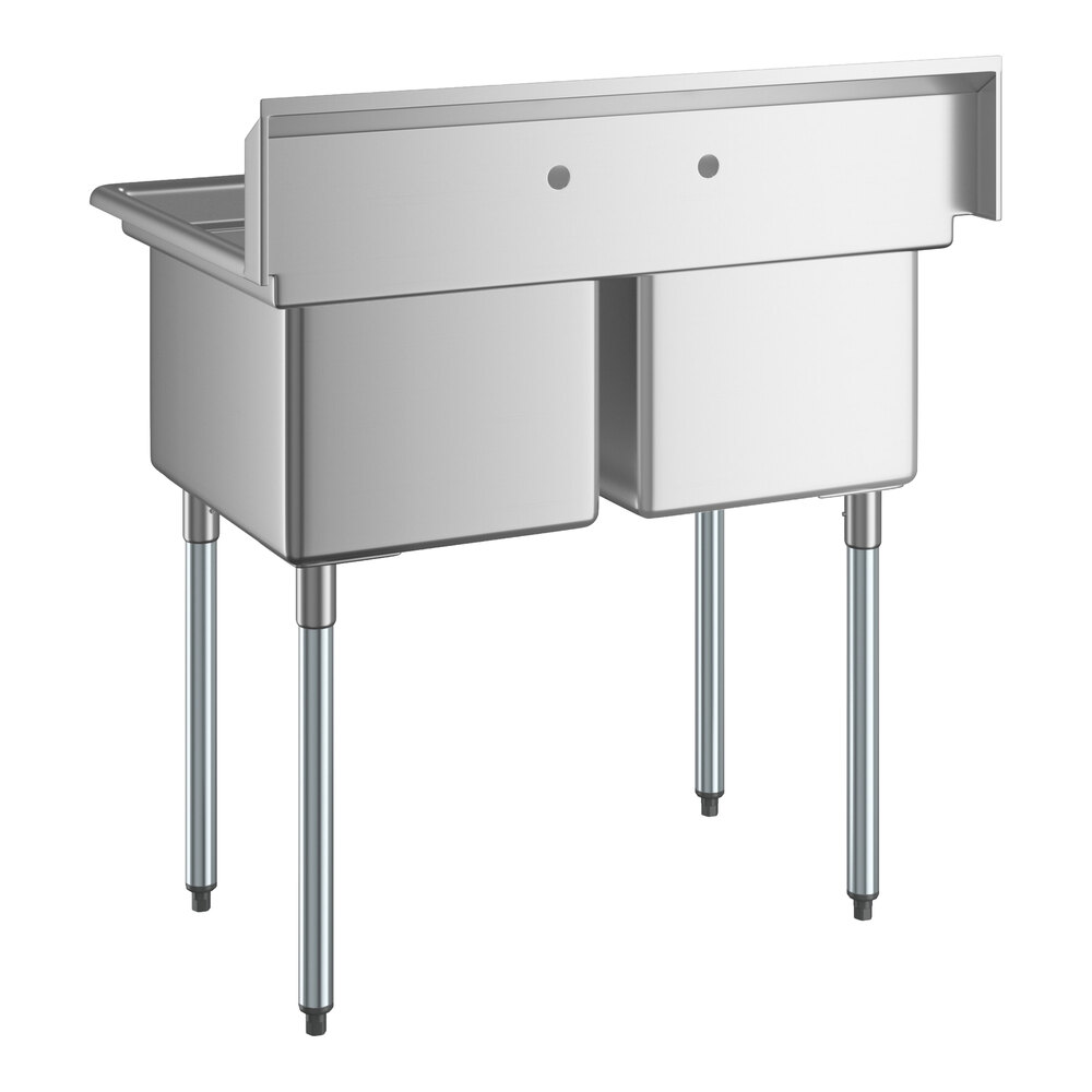 A stainless steel two-compartment sink with four metal legs and a high backsplash featuring two faucet holes.
