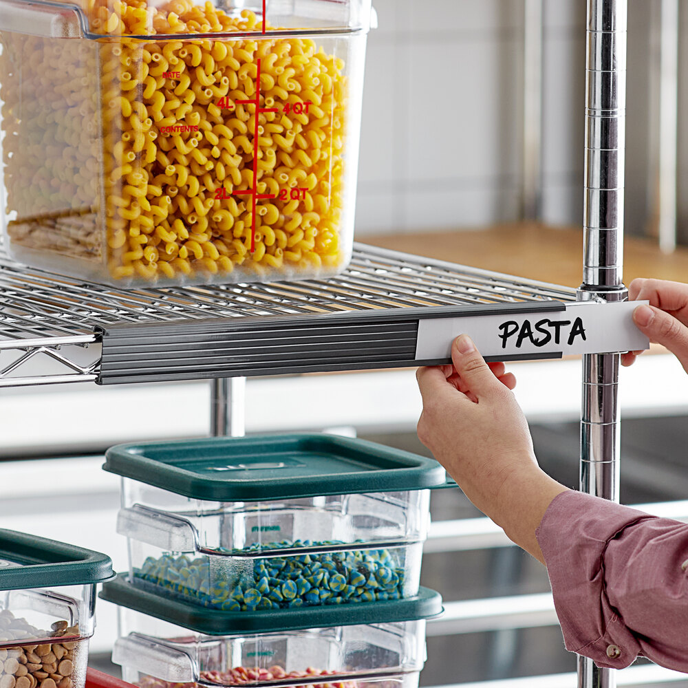 A gray label holder being attached to a wire shelving unit, with containers of food stored on the shelves.