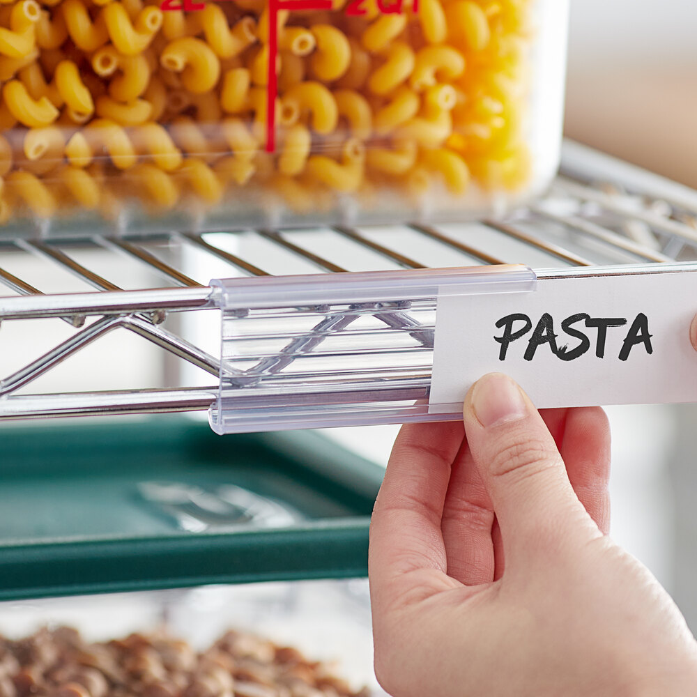 A clear plastic label holder attached to a wire shelving unit, displaying a label that reads 'PASTA.'