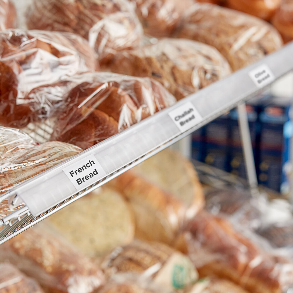 A clear clip-on label holder attached to a wire basket shelf, displaying product labels for bakery items.
