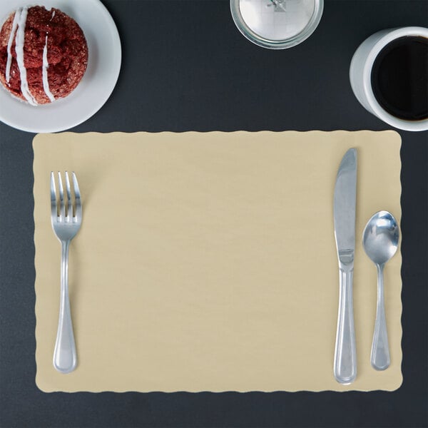 An ecru colored paper placemat with a scalloped edge and a fork and spoon on it.