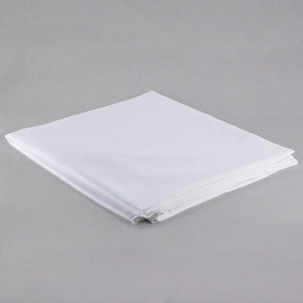 A folded white cloth on a gray surface.