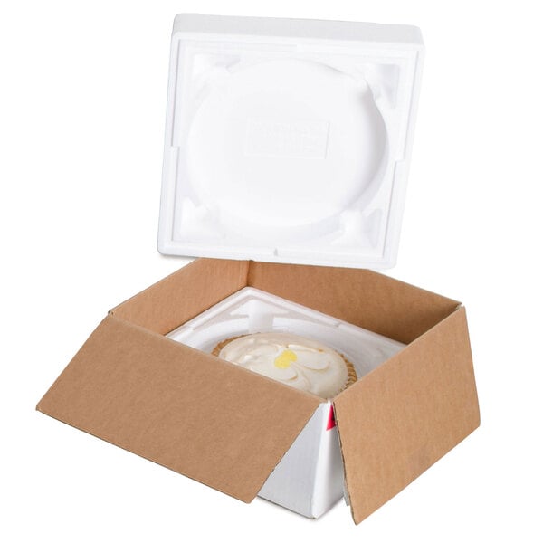A white foam box with a round white cake inside.