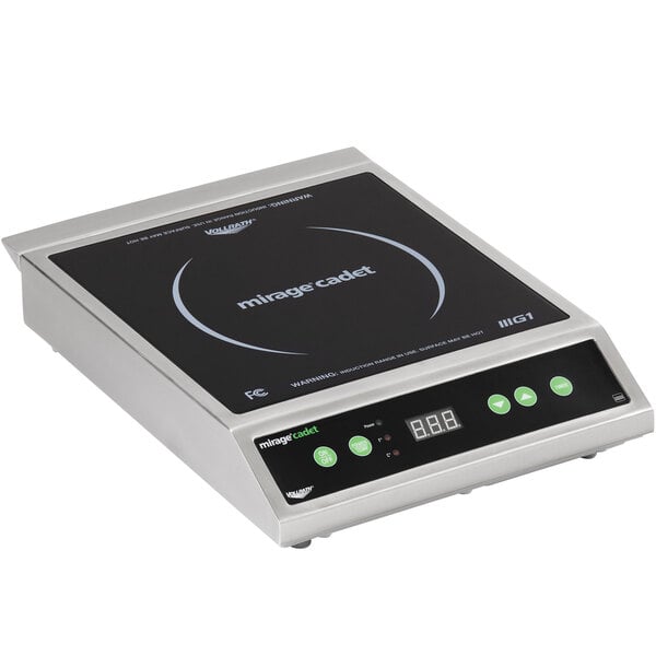 A Vollrath Mirage Cadet countertop induction range on a counter in a professional kitchen with green buttons.