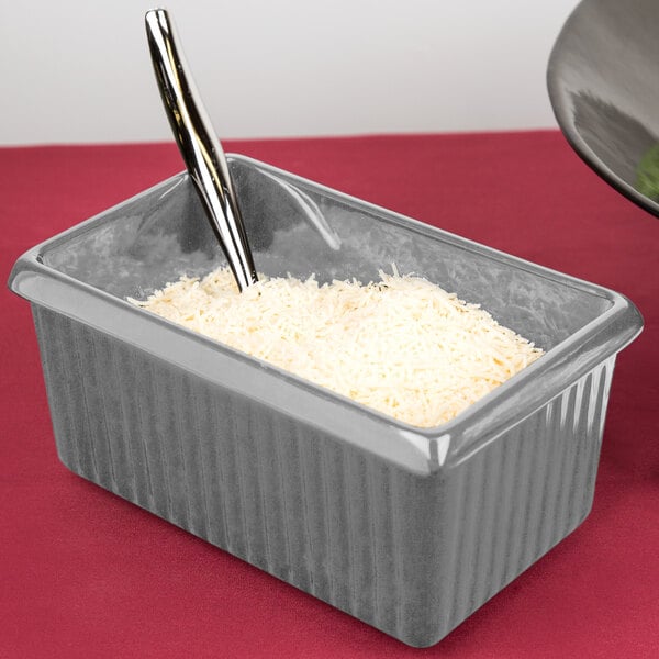 A Tablecraft natural rectangle server with white rice and a spoon.