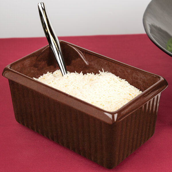 A brown rectangular Tablecraft server with white rice and a spoon in it.