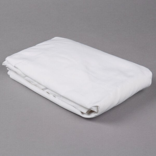 A folded white Oxford T300 Super Deluxe king size fitted sheet on a gray surface.