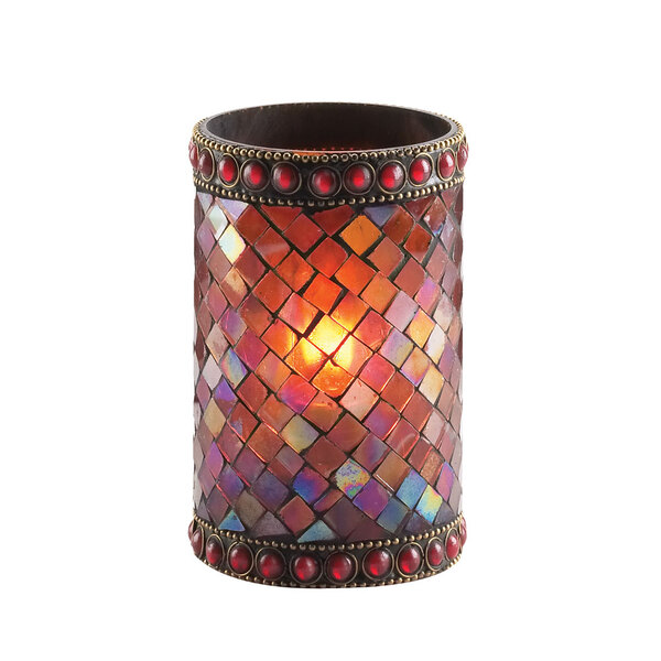 A close-up of a Sterno red beaded mosaic liquid candle holder with a lit candle inside.