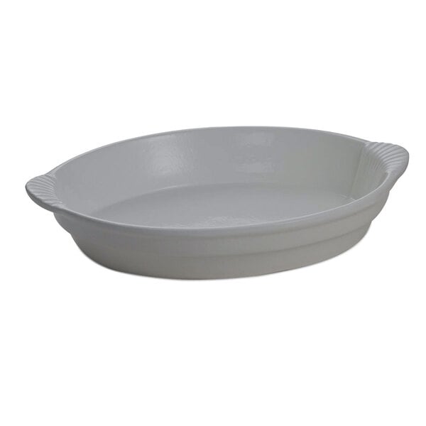 A natural cast aluminum oval dish with a handle.